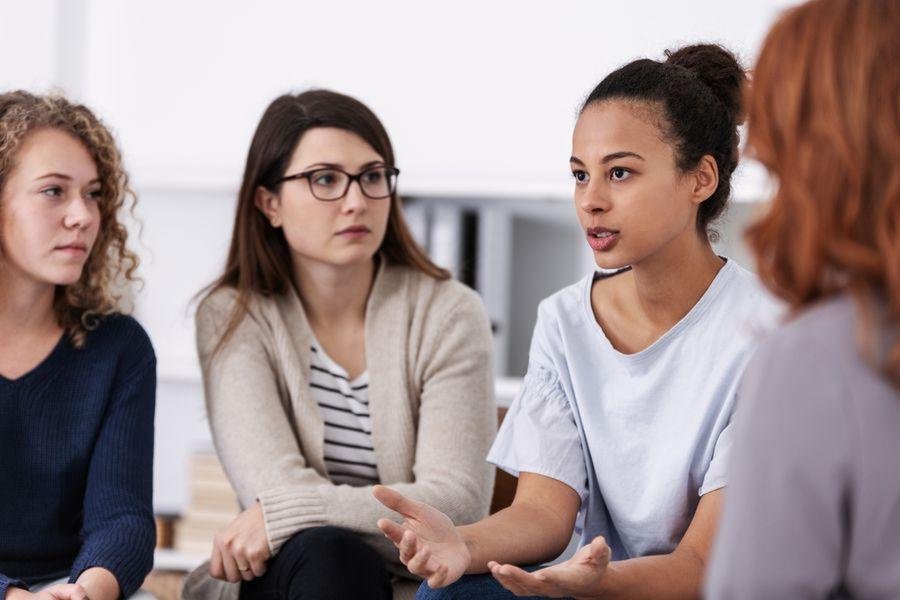 [Translate to Englisch:] Frauen sitzen nebeneinander und sind im Gespräch