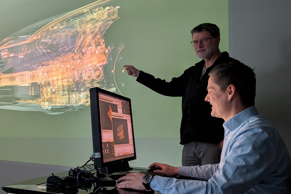 Prof. Dr. Tomas Sauer (stehend) und Prof. Dr. Christoph Heinzl demonstrieren die Visualisierung eines großen industriellen CT-Datensatzes in einer dreidimensionalen Darstellung.
