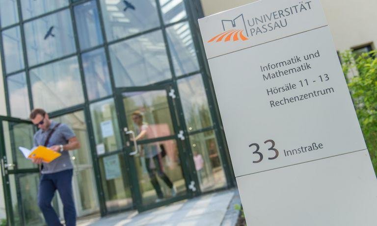Ein Student kommt aus dem Gebäude der Fakultät für Informatik und Mathematik heraus