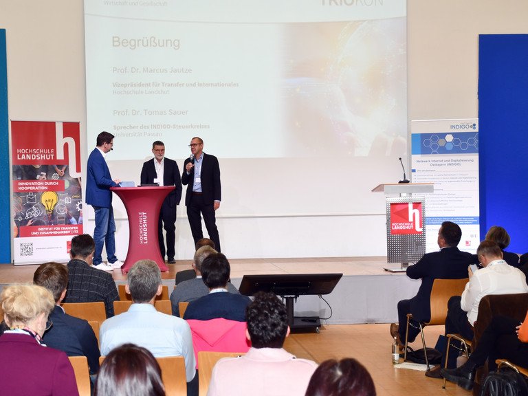 Prof. Dr. Tomas Sauer (Sprecher des INDIGO-Steuerkreises, Universit&auml;t Passau, Mitte) und Prof. Dr. Marcus Jautze (Vizepr&auml;sident der Hochschule Landshut, rechts) im Gespr&auml;ch mit Moderator Marcel Meinert; Foto: Hochschule Landshut