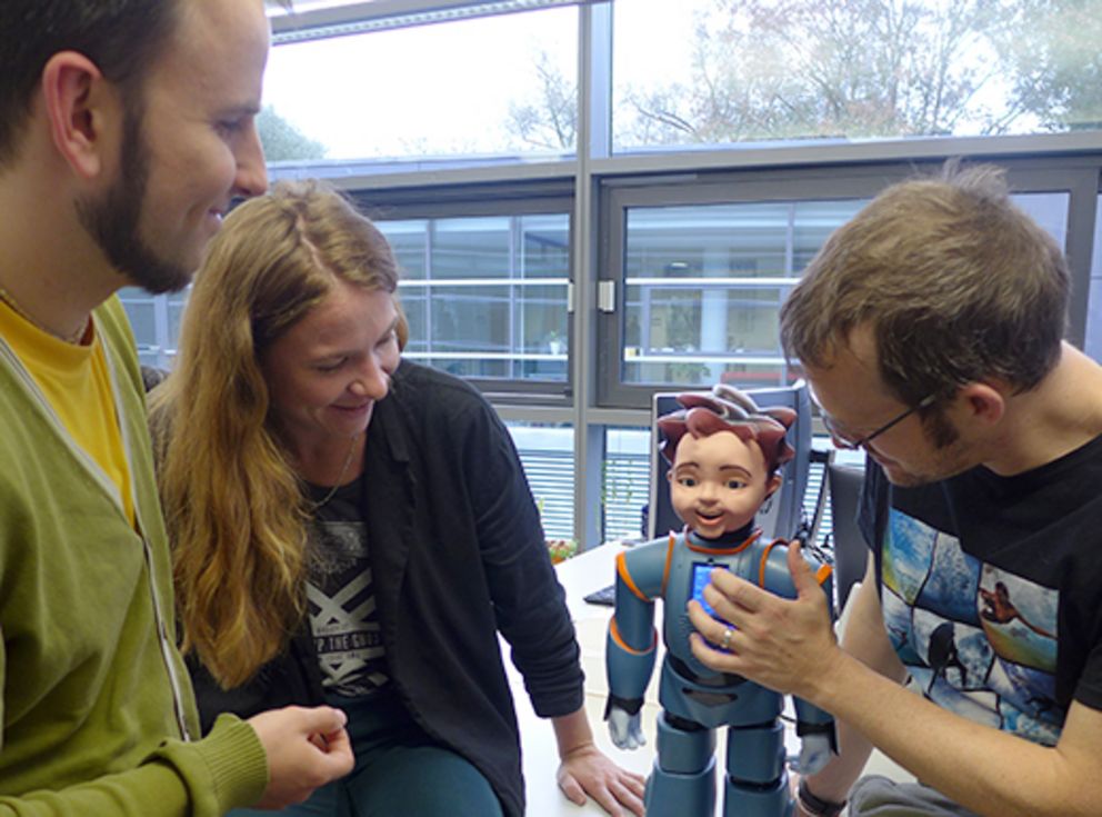 Gerhard Hagerer (von links), Alice Baird, und Dr. Nicholas Cummins vom Lehrstuhl für Complex and Intelligent Systems trainieren mit dem humanoiden Roboter des Modells "Zeno".